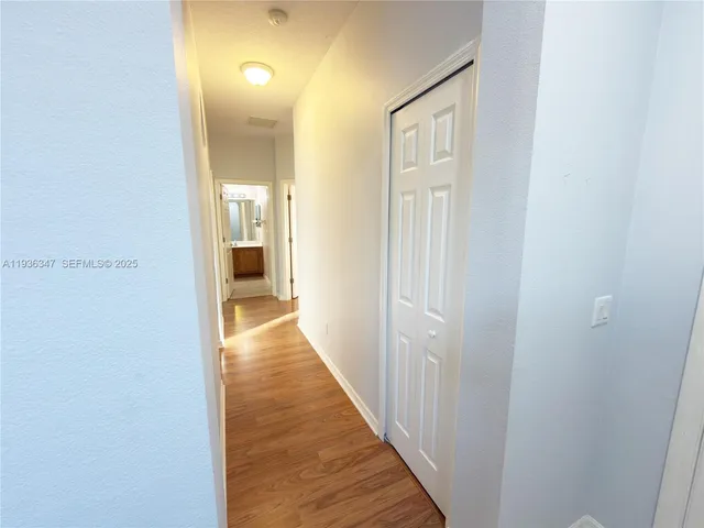 a view of a hallway with wooden floor