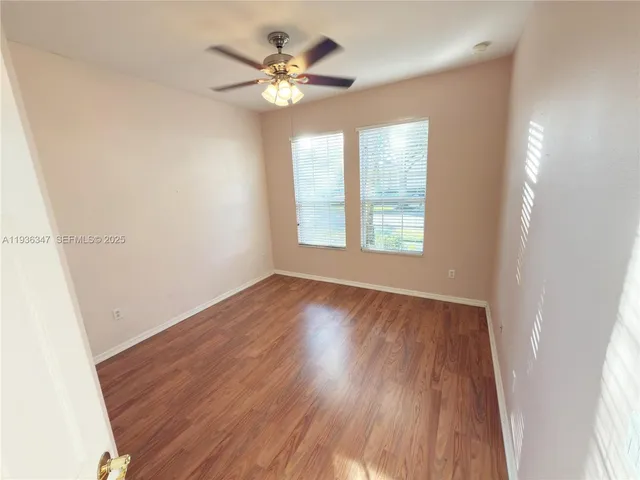 an empty room with wooden floor and window