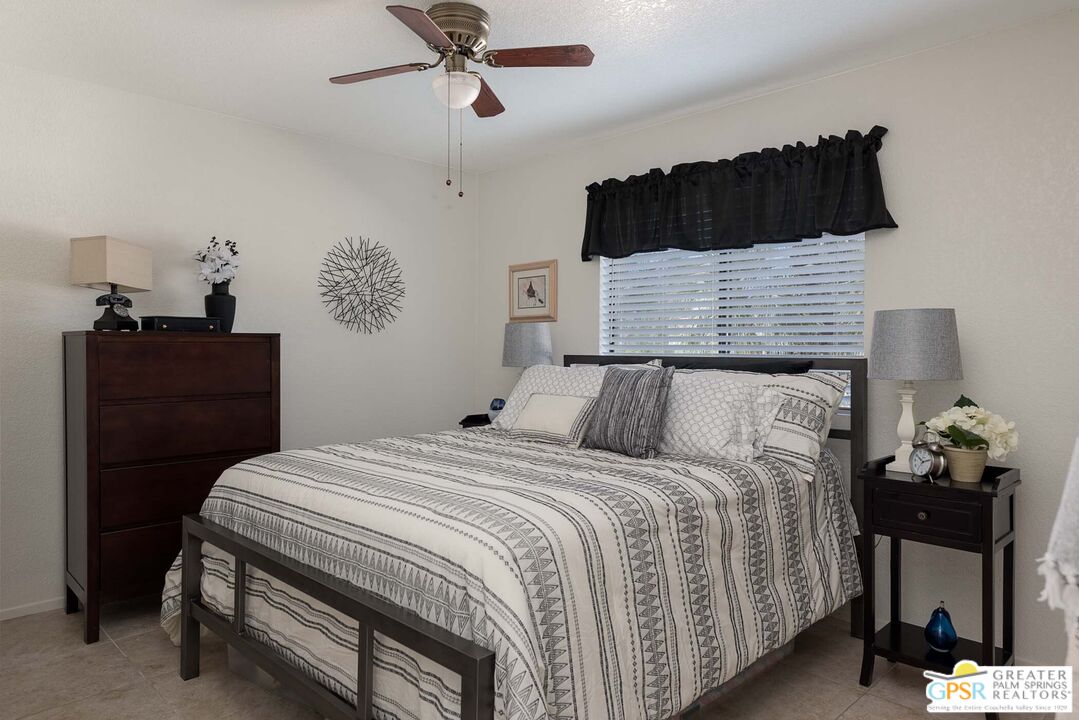 9760 Capiland Road Desert Hot Springs, CA 92240 - Photo 12 of 16 a bedroom with a bed a dresser and potted plants
