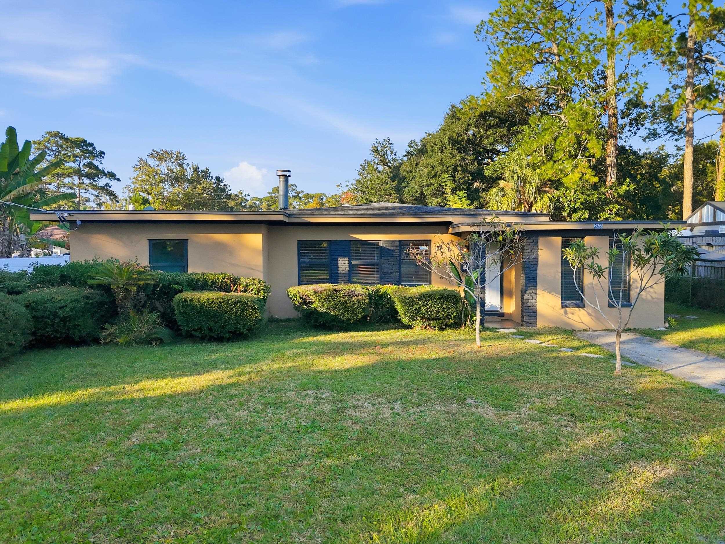 a view of a house with a yard and sitting area