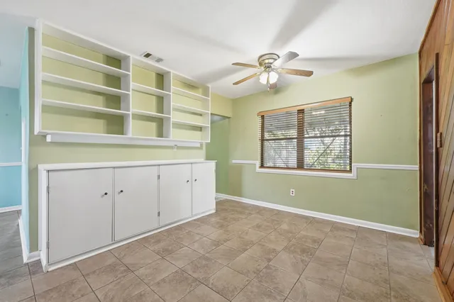 a view of an empty room with a window and cabinet