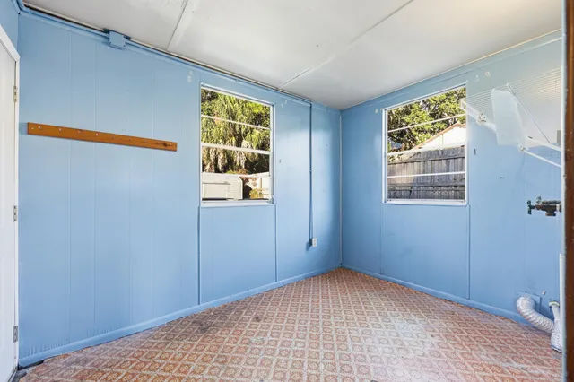 a view of an empty room with window and stairs