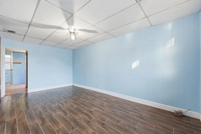 a view of an empty room with wooden floor