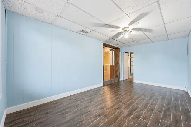 a view of an empty room with window and wooden floor