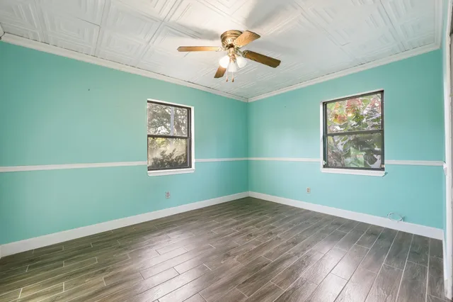 a view of room with window ceiling fan and wooden floor