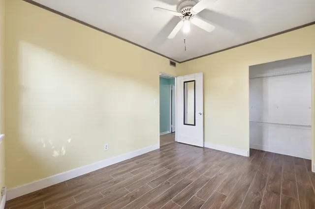 a view of an empty room with wooden floor