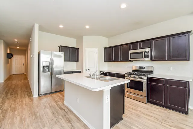 a kitchen with wooden cabinets and a stove top oven