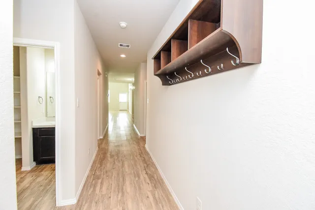 a view of a hallway with wooden floor