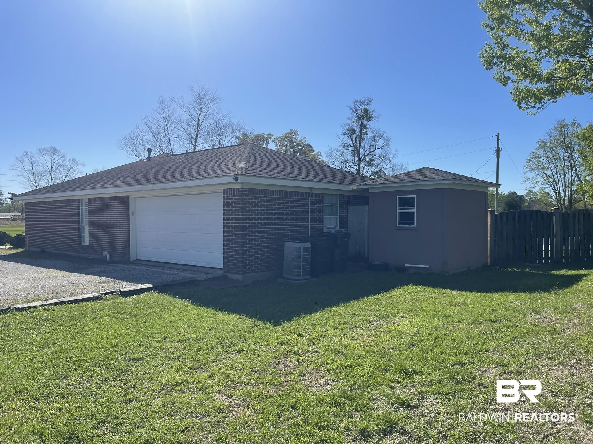 35405 Pine Road South Stapleton, AL 36578 - Photo 25 of 29 Rear view of property featuring a garage, brick siding, roof with shingles, and driveway