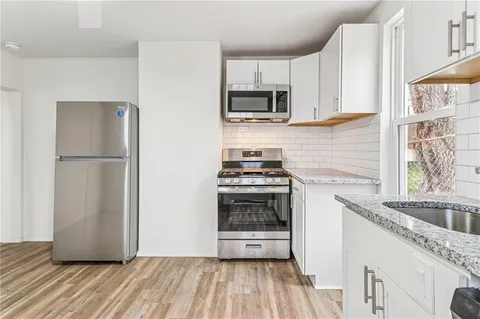 a kitchen with granite countertop a refrigerator and a sink