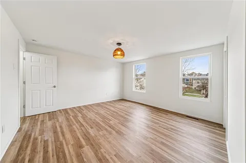 a view of empty room with wooden floor and window