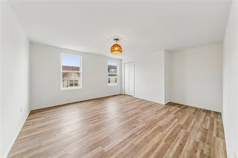 an empty room with window and wooden floor