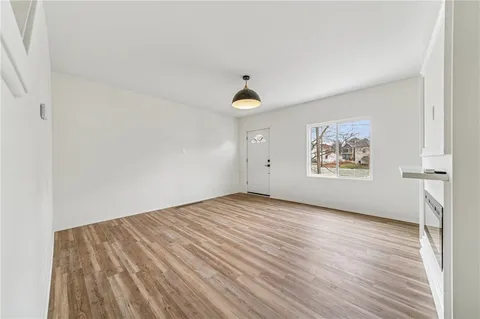 an empty room with wooden floor and window