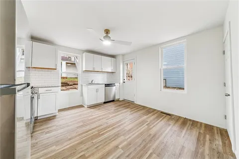 a kitchen with white cabinets and white appliances