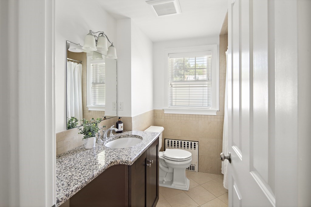 106 Florence Avenue Arlington, MA 02476 - Photo 22 of 32 a bathroom with a granite countertop sink toilet and mirror
