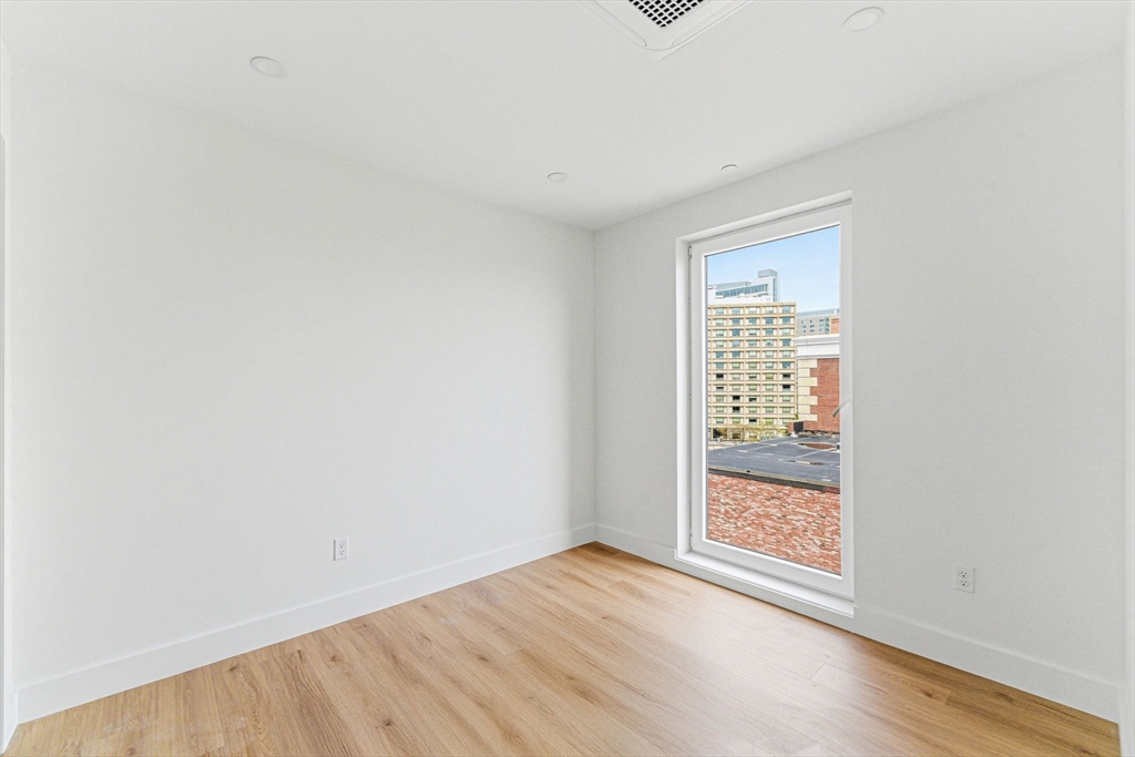 1035 Commonwealth Avenue, Unit 608 Boston, MA 02215 - Photo 3 of 13 an empty room with wooden floor and windows