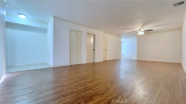 a view of an empty room with wooden floor