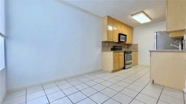 a kitchen with granite countertop a stove top oven and cabinets
