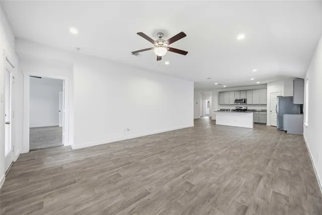 a view of a kitchen with a sink and dishwasher a refrigerator with wooden floor
