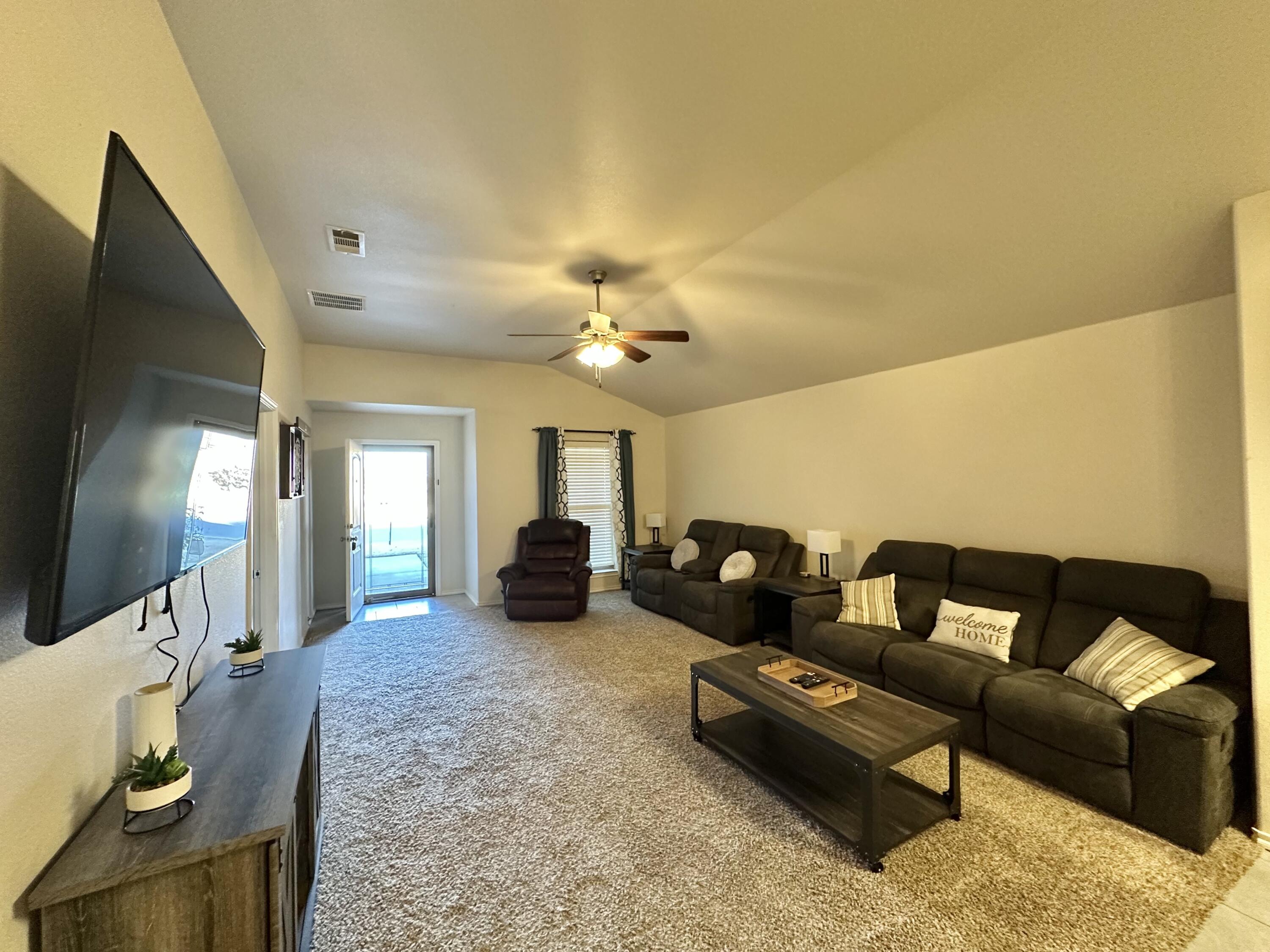 10411 Valencia Avenue Lubbock, TX 79424 - Photo 3 of 16 a living room with furniture and a flat screen tv