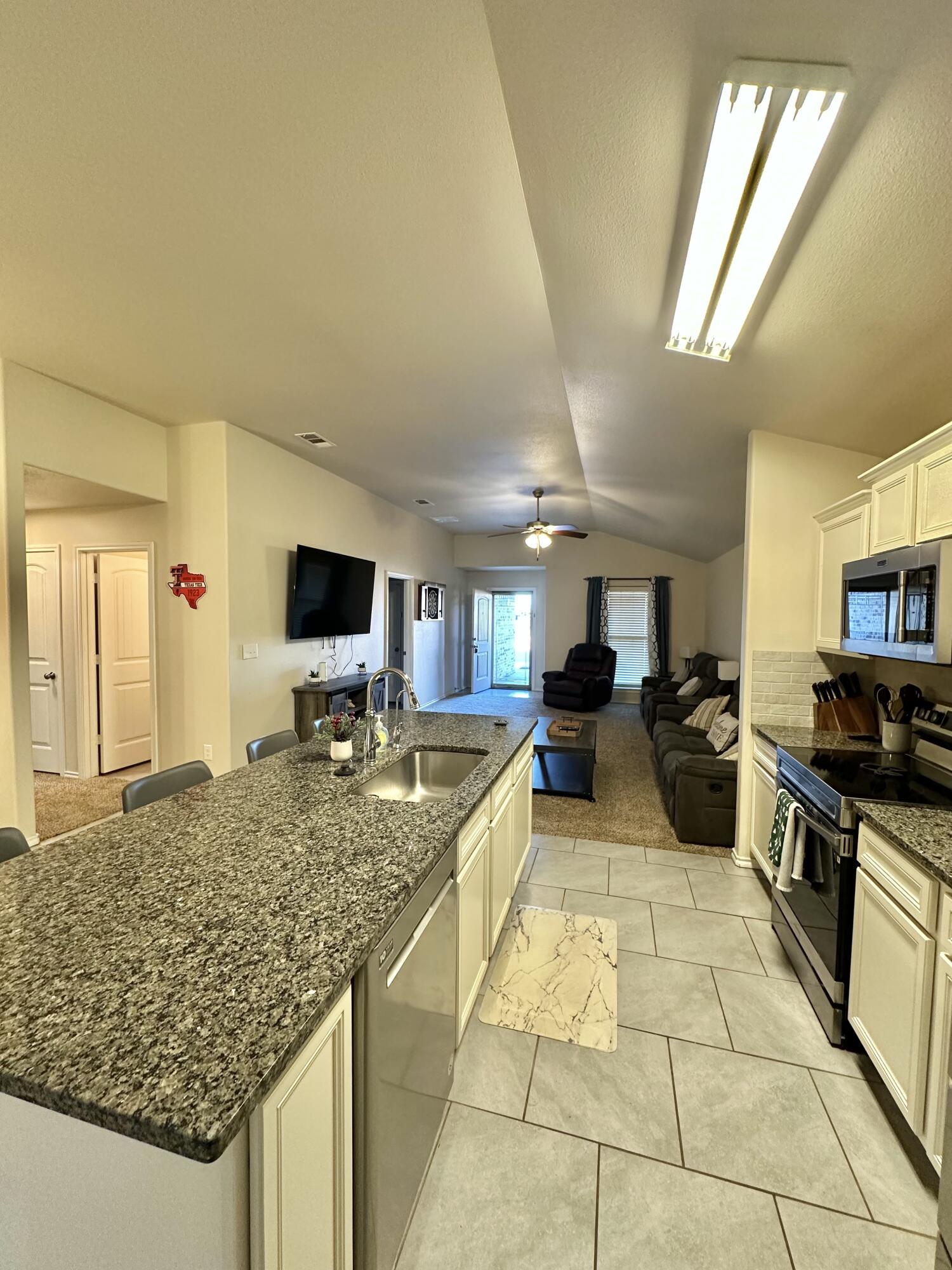 10411 Valencia Avenue Lubbock, TX 79424 - Photo 5 of 16 a kitchen with stainless steel appliances granite countertop a sink and cabinets