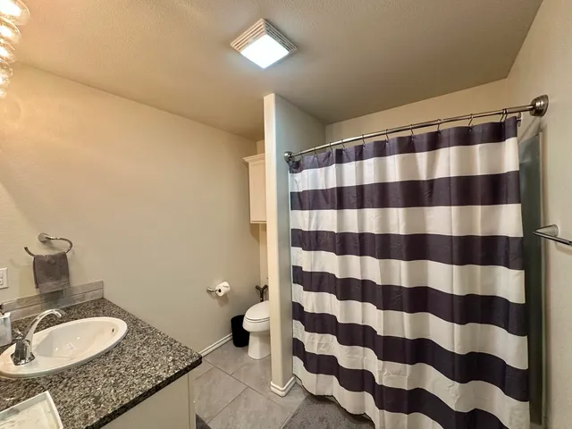 a bathroom with a granite countertop sink and mirror