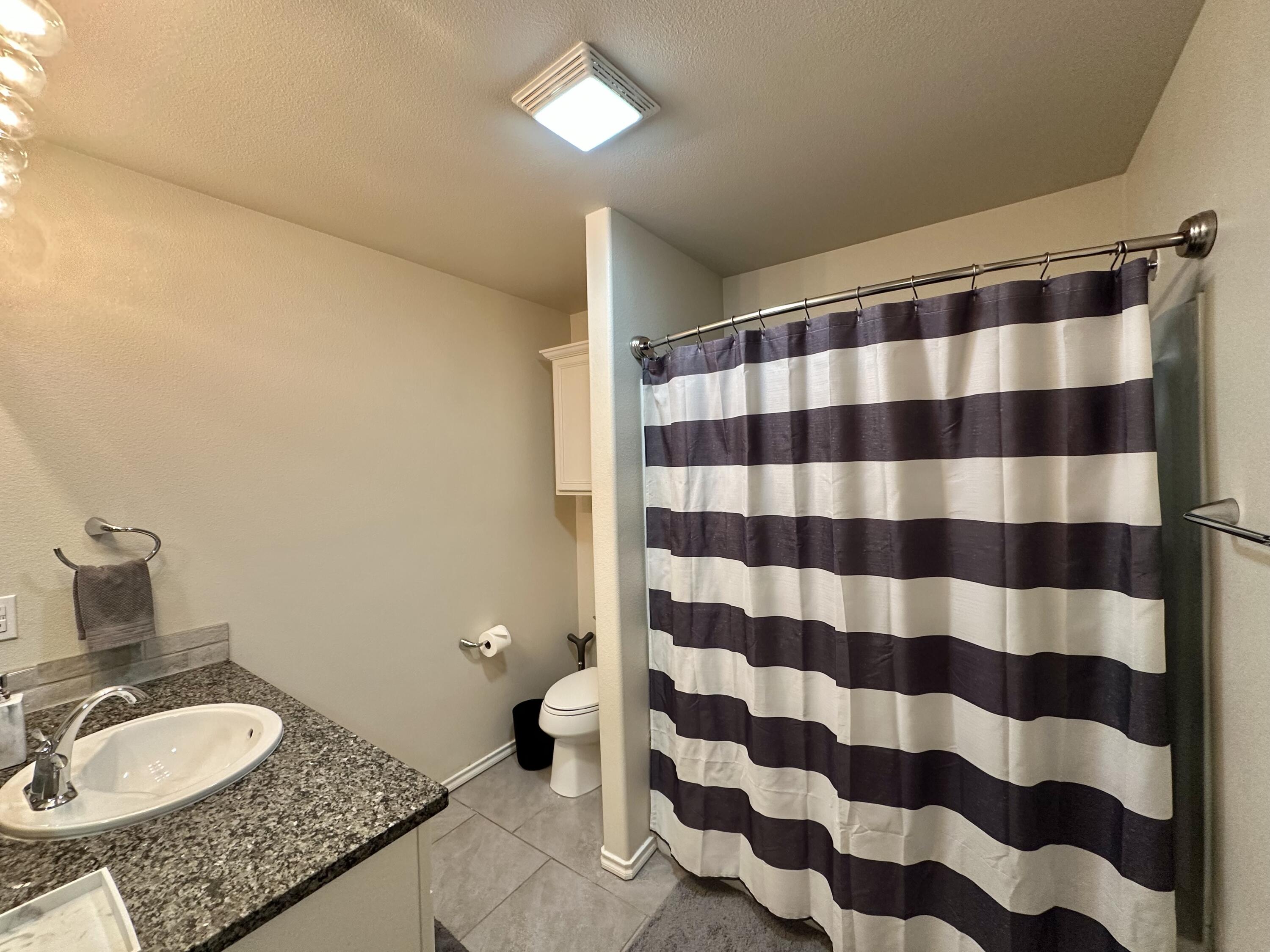 10411 Valencia Avenue Lubbock, TX 79424 - Photo 8 of 16 a bathroom with a granite countertop sink and mirror