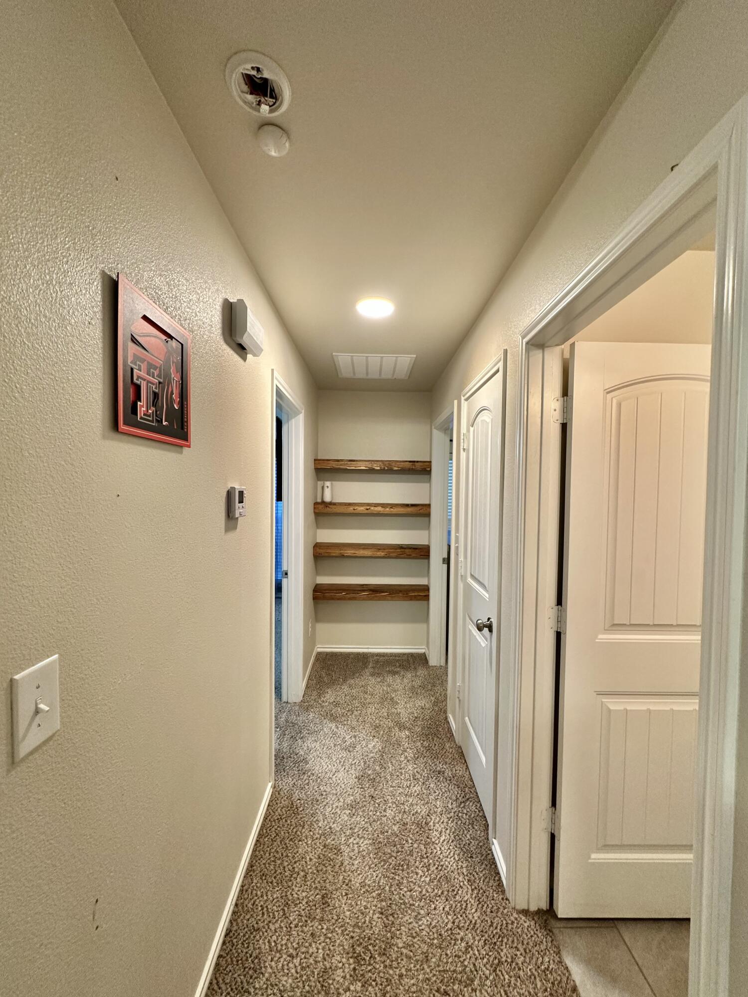 10411 Valencia Avenue Lubbock, TX 79424 - Photo 10 of 16 a view of a hallway with wooden shelves