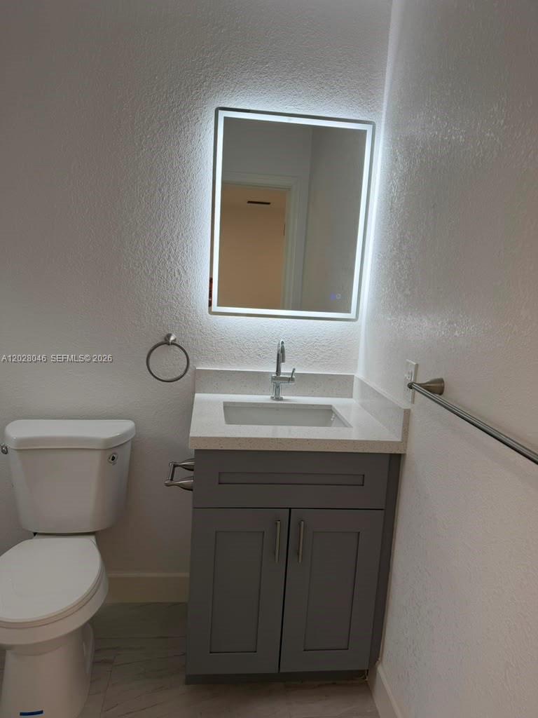 19321 Southwest 196th Street, Unit 1 Miami, FL 33187 - Photo 3 of 10 a bathroom with a toilet sink and mirror