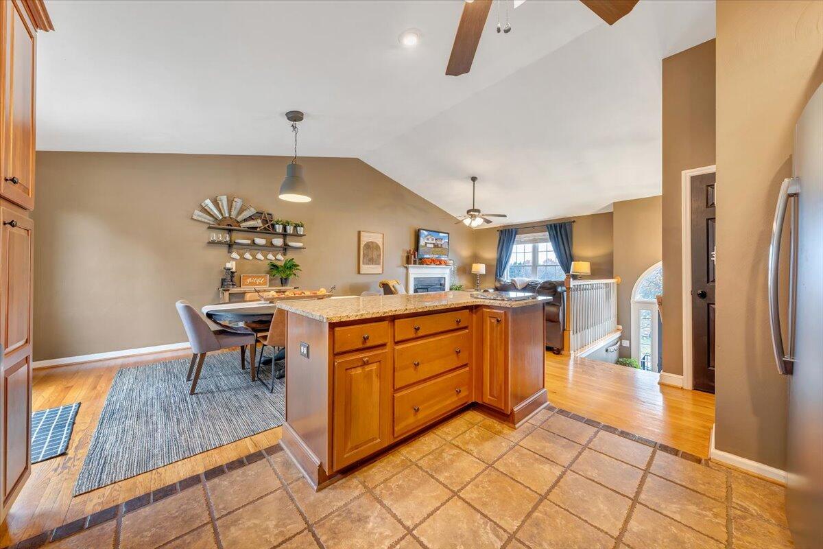 1748 Meadows Road Vinton, VA 24179 - Photo 14 of 34 a kitchen with stainless steel appliances kitchen island granite countertop a refrigerator a stove a dining table and chairs with wooden floor