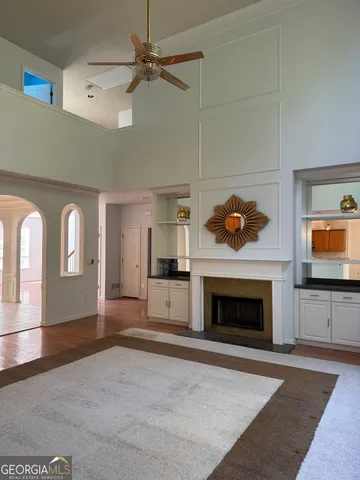 an empty room with windows fireplace and cabinet