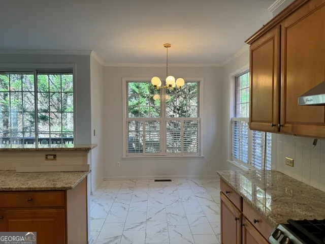 a kitchen with granite countertop a stove a sink and a counter space