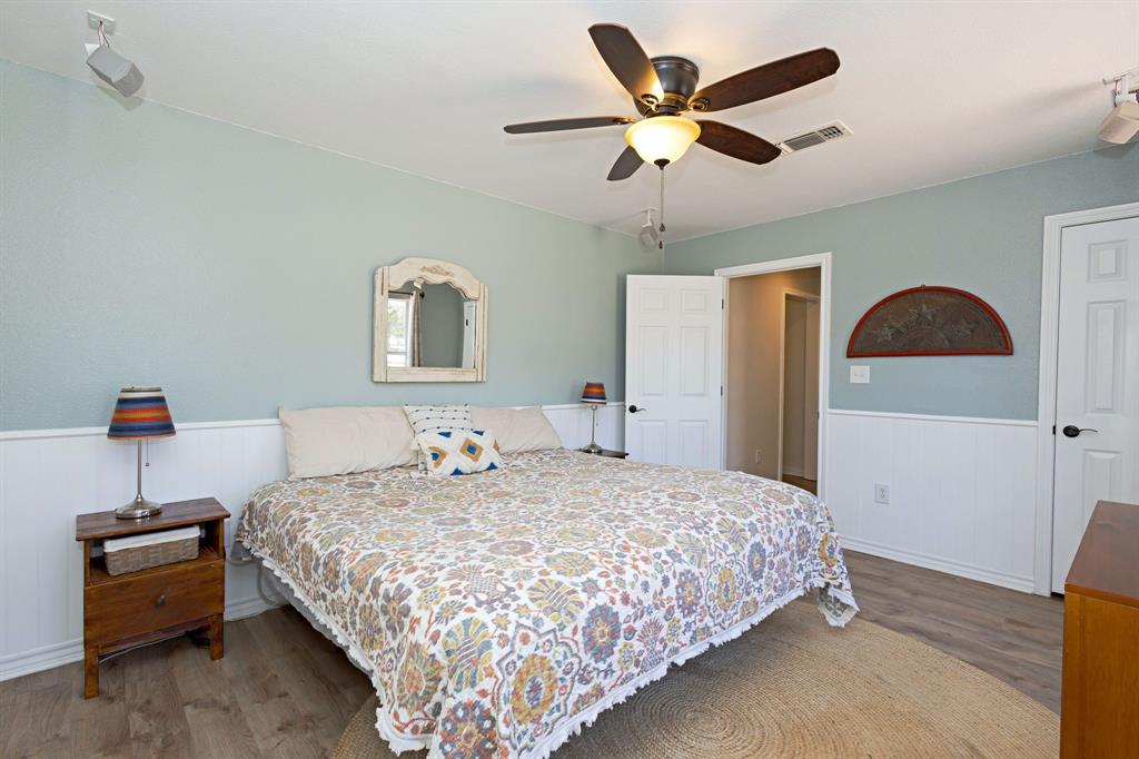 13508 Deussen Road Ponder, TX 76259 - Photo 19 of 40 a bedroom with a bed and a chandelier