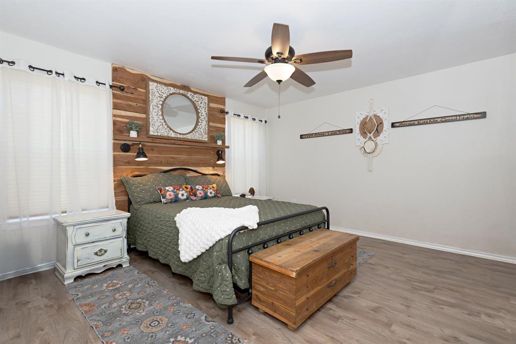 13508 Deussen Road Ponder, TX 76259 - Photo 28 of 40 a bedroom with a bed and a chandelier