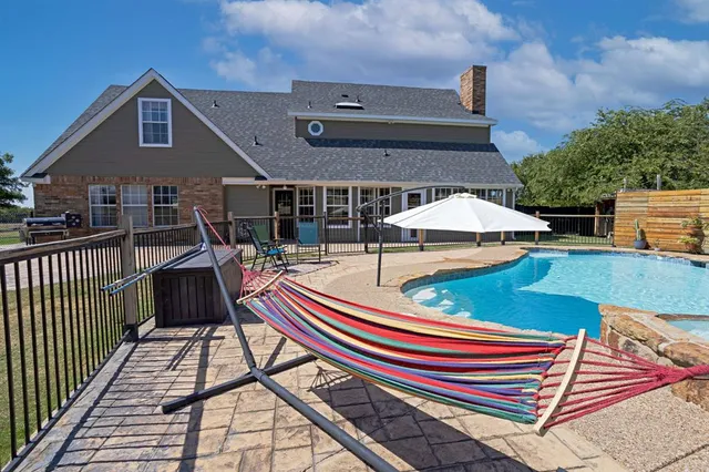 a swimming pool with outdoor seating and yard