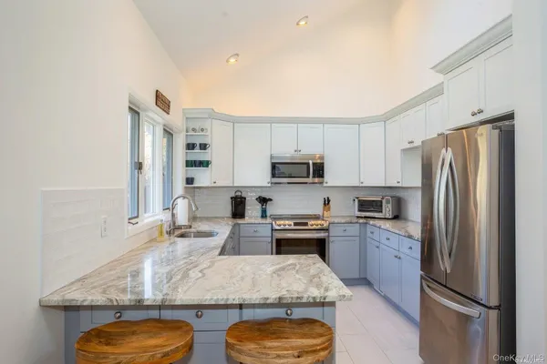 a kitchen with stainless steel appliances granite countertop a sink refrigerator and microwave