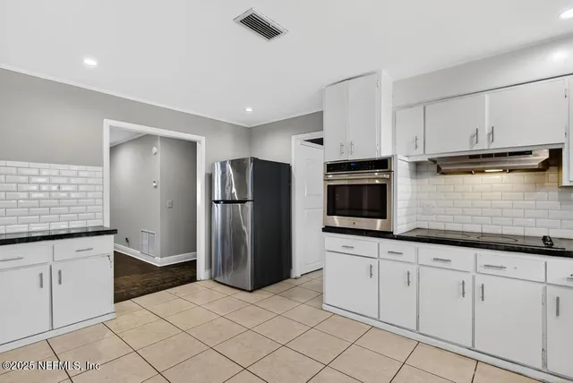 a kitchen with stainless steel appliances a refrigerator sink and microwave