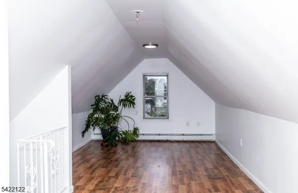 a view of an empty room with wooden floor and closet