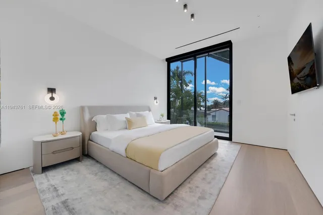 a bedroom with a large bed and large windows