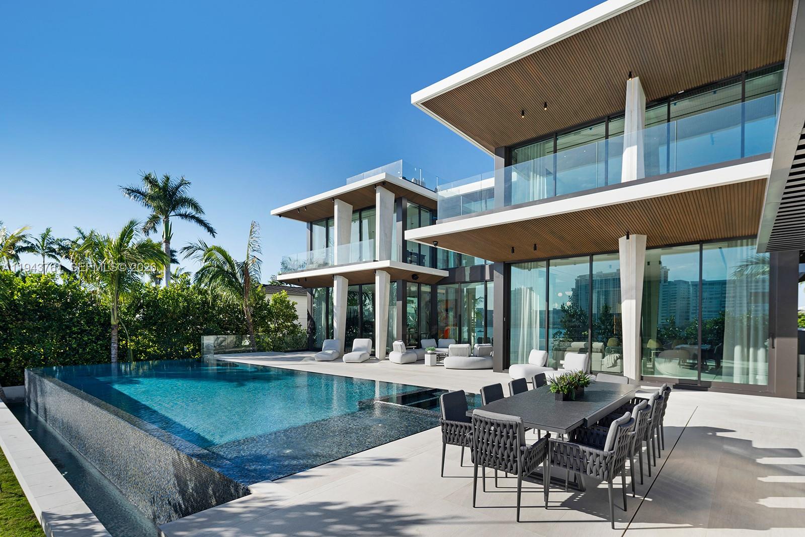 217 East Rivo Alto Drive Miami Beach, FL 33139 - Photo 50 of 87 a view of a patio with couches table and chairs with potted plants and palm trees