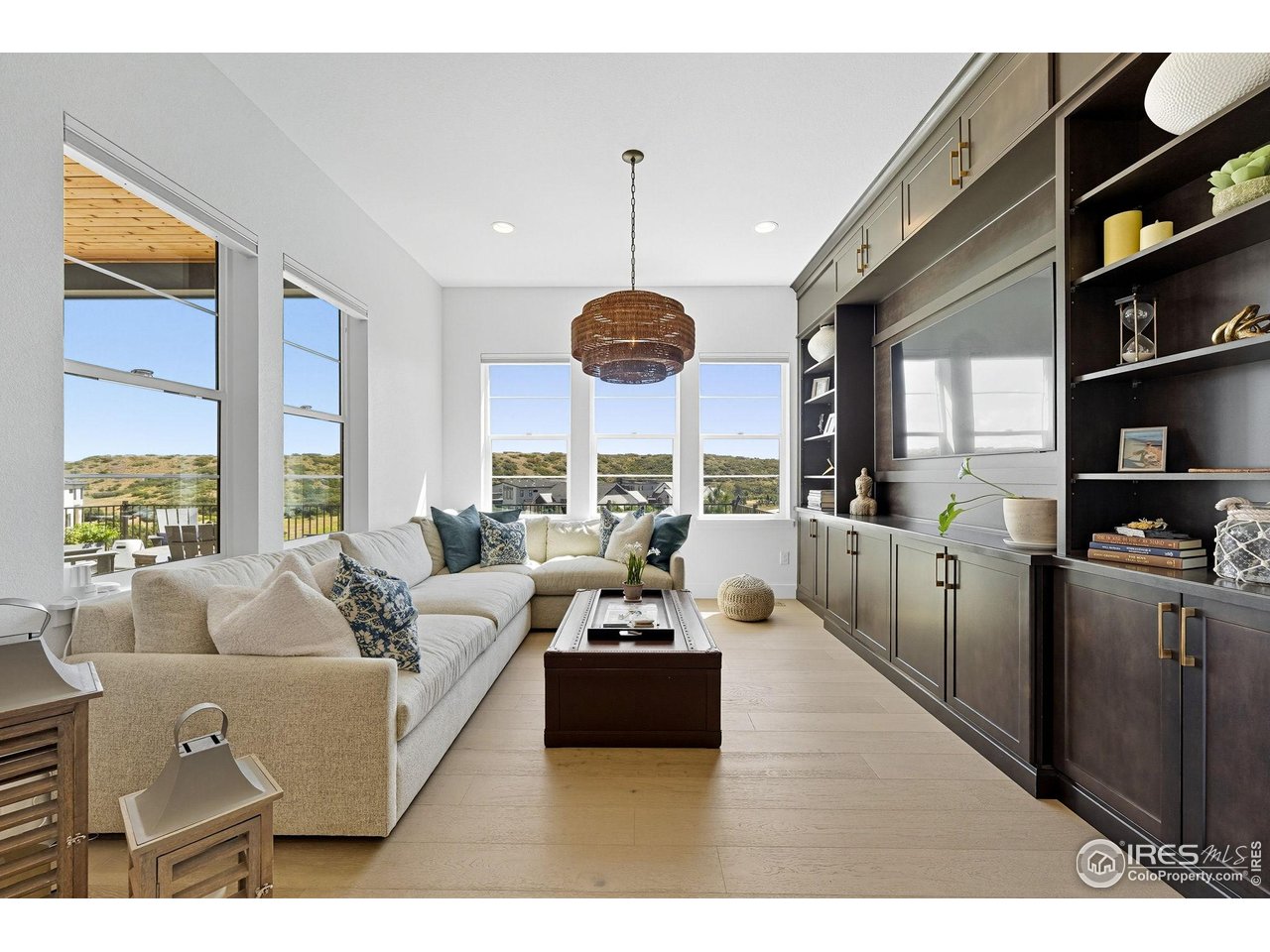 7382 Canyonpoint Road Castle Pines, CO 80108 - Photo 16 of 49 a living room with furniture a chandelier and a large window