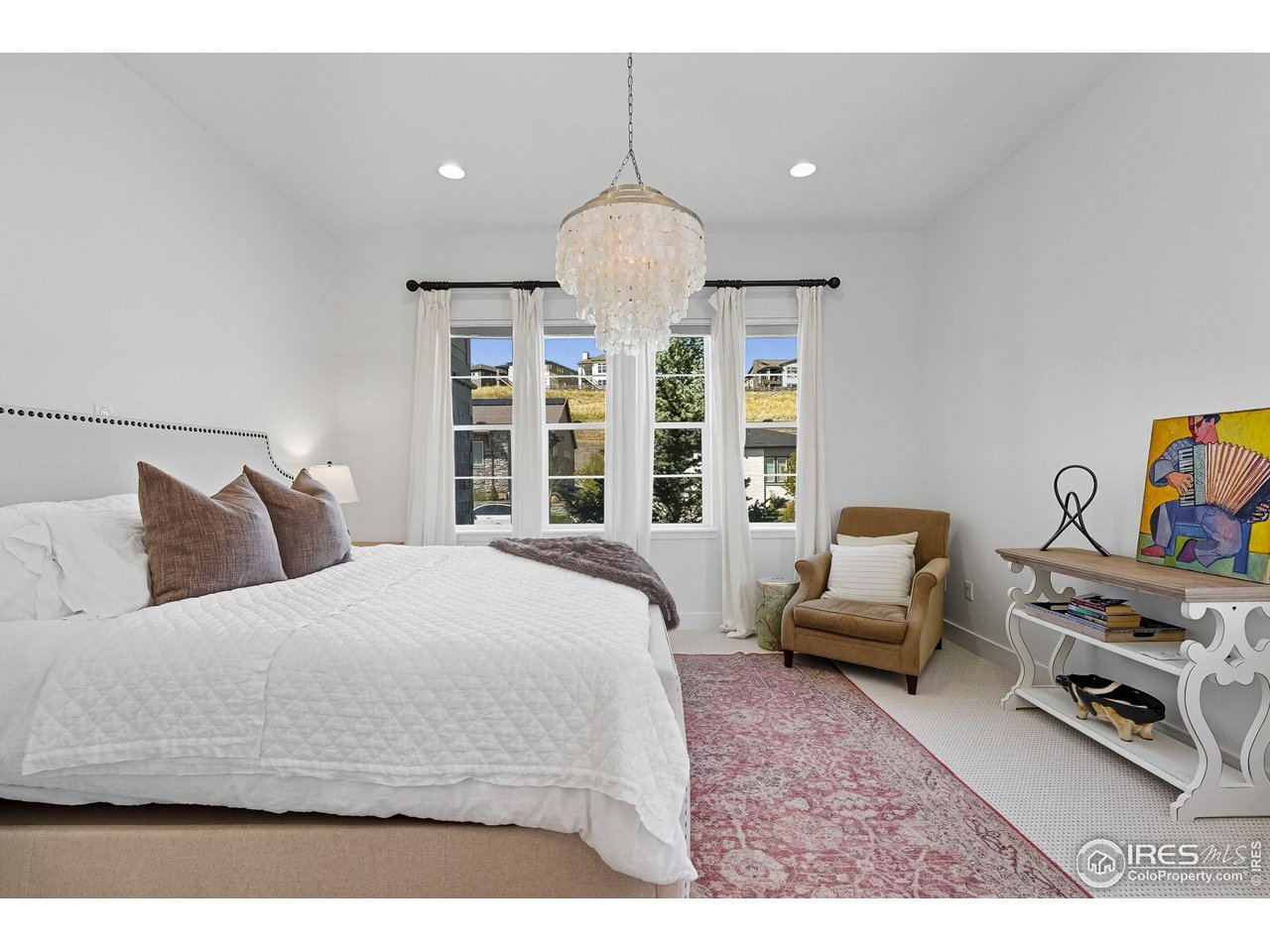 7382 Canyonpoint Road Castle Pines, CO 80108 - Photo 30 of 49 a bedroom with a bed a couch and a chandelier