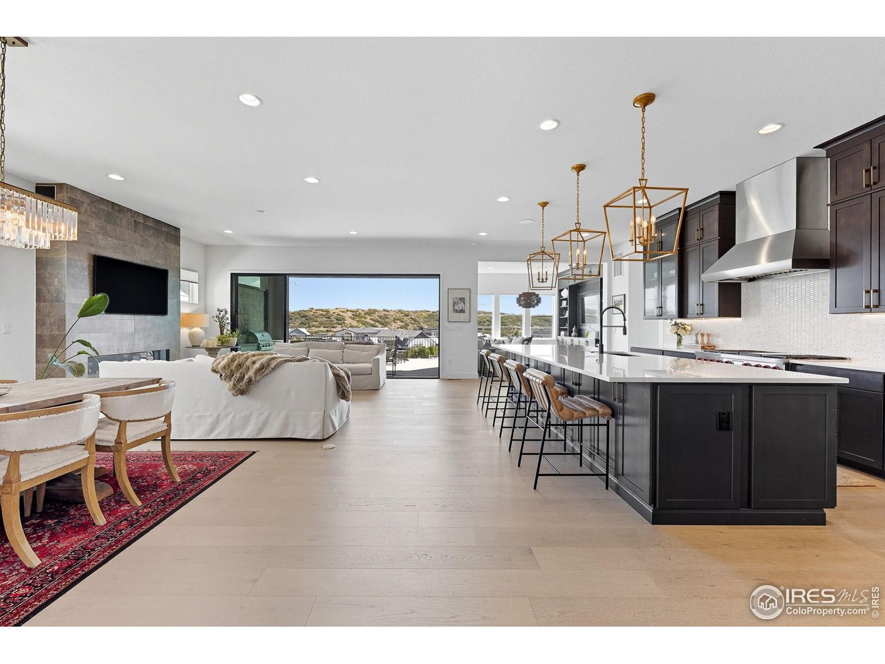 7382 Canyonpoint Road Castle Pines, CO 80108 - Photo 3 of 49 a living room with stainless steel appliances kitchen island granite countertop furniture a rug kitchen view and a chandelier