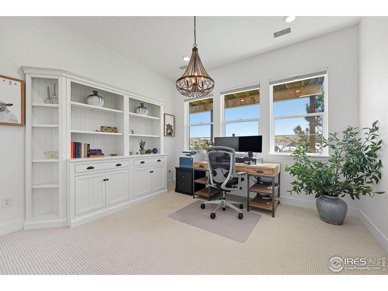 7382 Canyonpoint Road Castle Pines, CO 80108 - Photo 32 of 49 a living room with furniture a chandelier a window and a flat screen tv