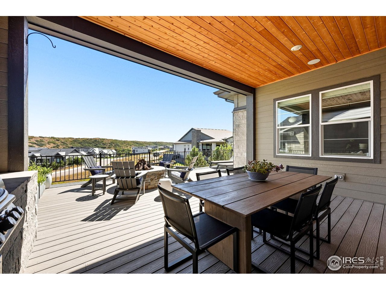 7382 Canyonpoint Road Castle Pines, CO 80108 - Photo 37 of 49 a view of a roof deck with table and chairs and wooden floor