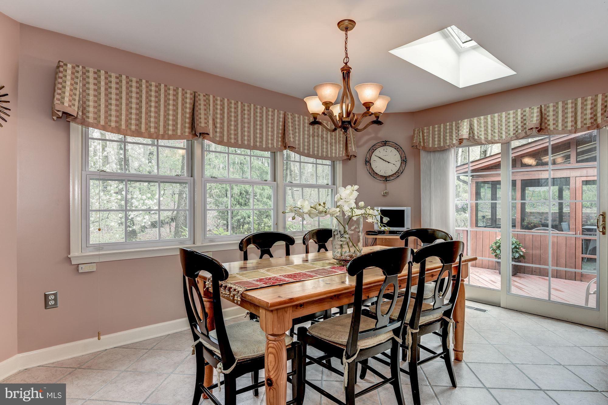 9204 Fall River Lane Potomac, MD 20854 - Photo 11 of 30 a view of a dining room with furniture a chandelier and a large window