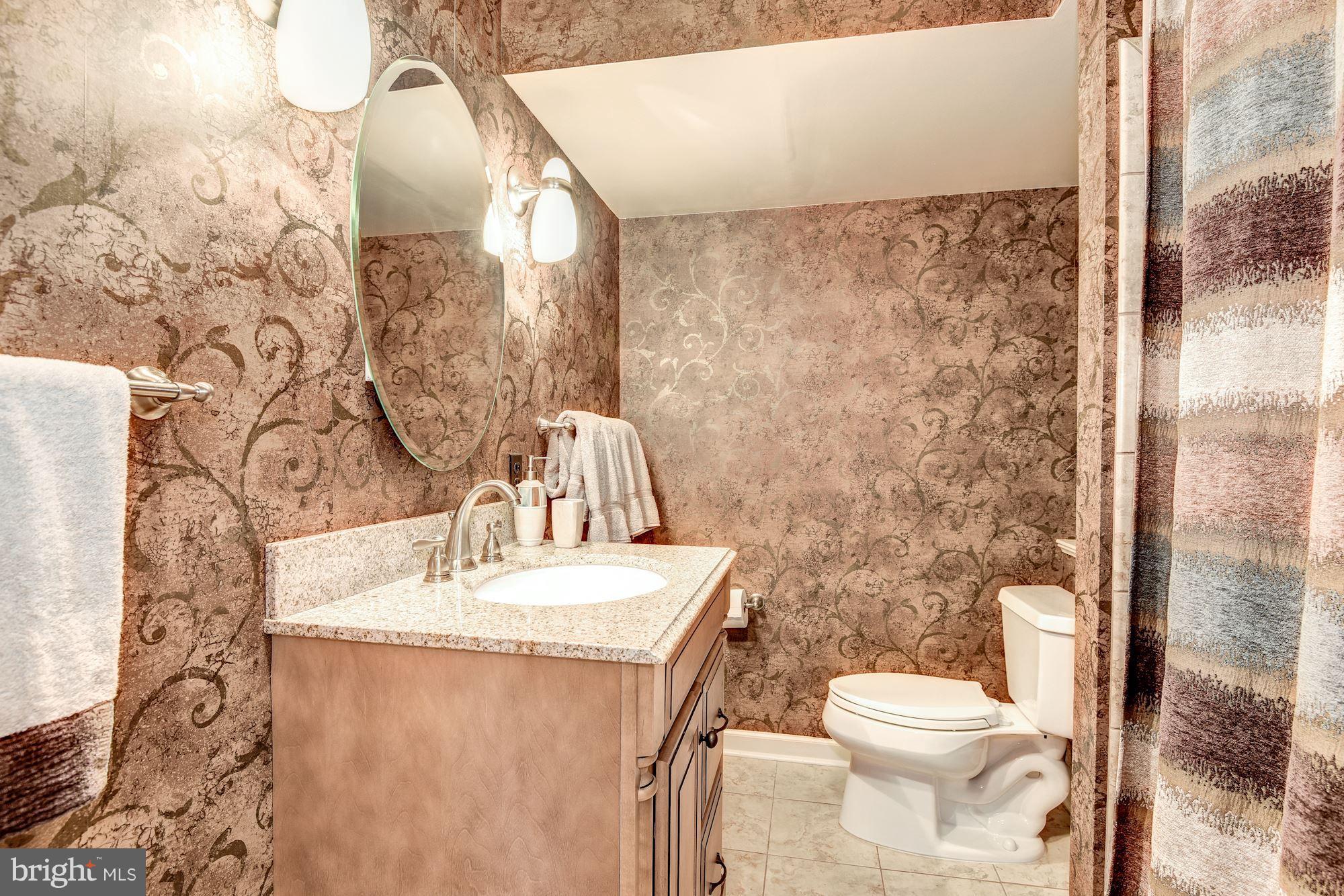 9204 Fall River Lane Potomac, MD 20854 - Photo 27 of 30 a bathroom with a toilet sink and mirror