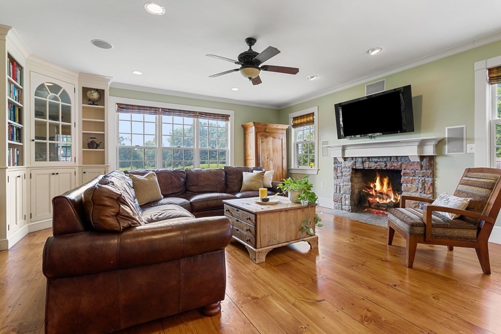 44 Old Ayer Road Groton, MA 01450 - Photo 12 of 41 a living room with furniture a flat screen tv and a fireplace