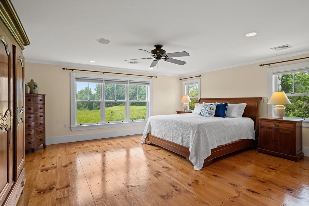 44 Old Ayer Road Groton, MA 01450 - Photo 18 of 41 a spacious bedroom with a large bed and a chandelier