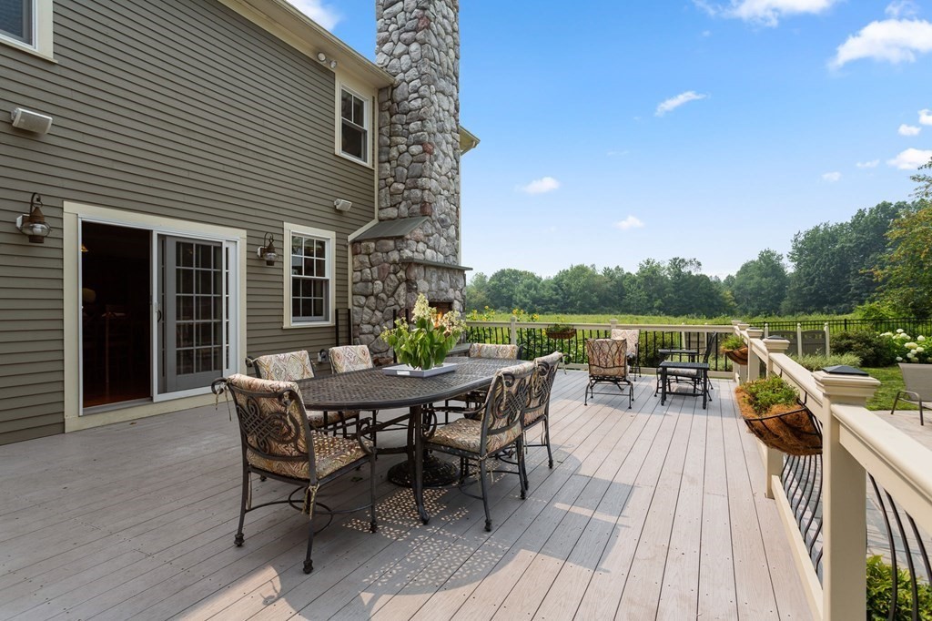 44 Old Ayer Road Groton, MA 01450 - Photo 34 of 41 a roof deck with table and chairs and wooden floor